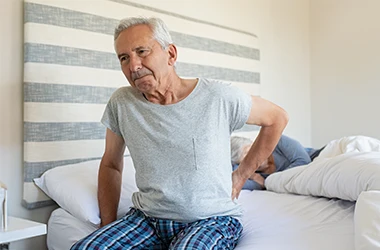Senior-Man-Suffering-From-Back-Pain-Symptom-Drop.webp