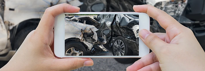 Person photographing car crash damage before chiropractic help Person photographing car crash damage before chiropractic help