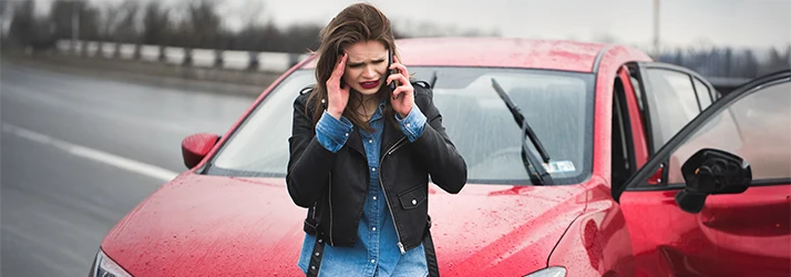 Woman calling for help after car accident with neck pain Woman calling for help after car accident with neck pain